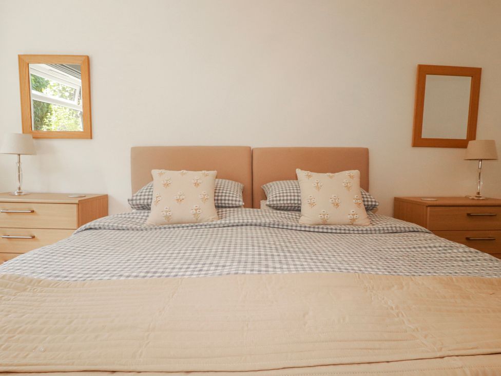 A bedroom with a bed and bedside tables at Camelia Cottage in St. Austell