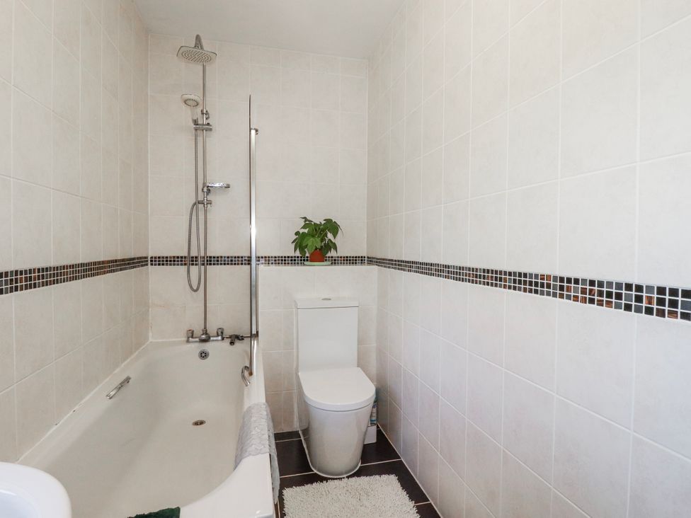 A bathroom featuring a bathtub and a toilet at Camelia Cottage St. Austell
