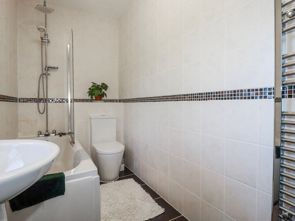 A bathroom featuring a bathtub and shower at Camelia Cottage in St. Austell
