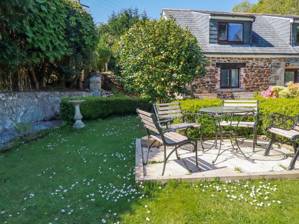 A garden with a table and chairs at Camelia Cottage St. Austell