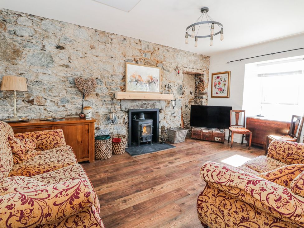 A living room with a fireplace and television at Schoolhouse in Oban