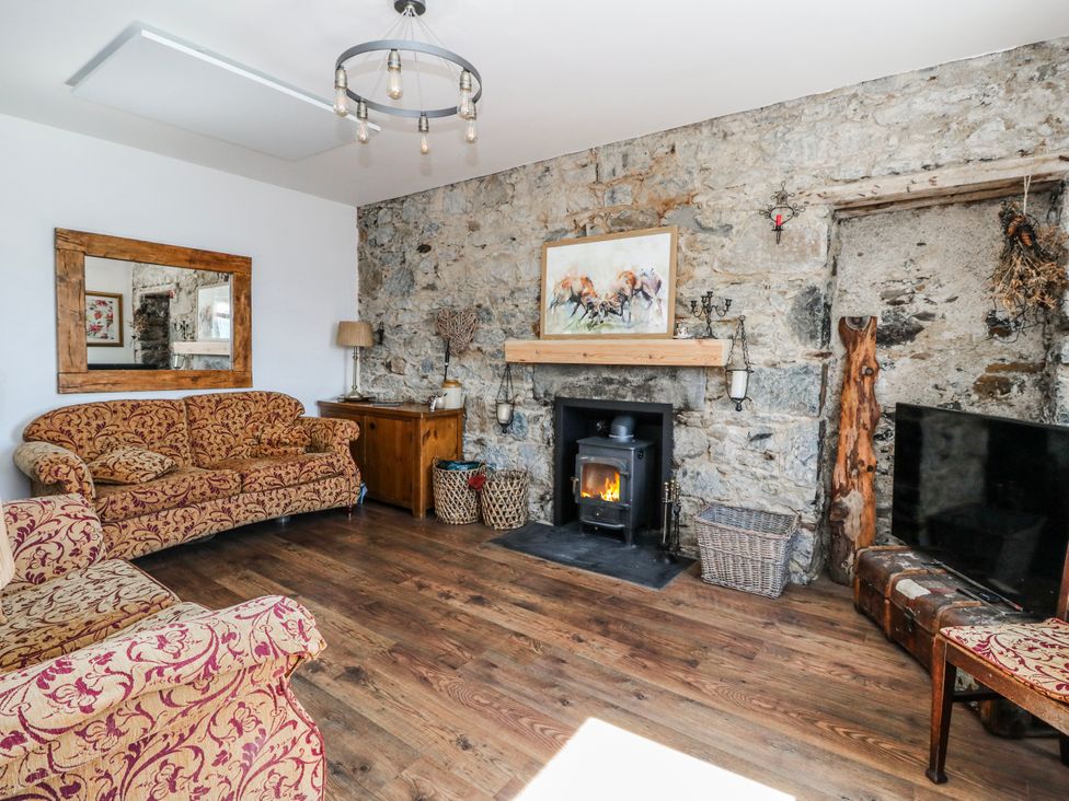 A living room with a fireplace and sofa at Schoolhouse in Oban
