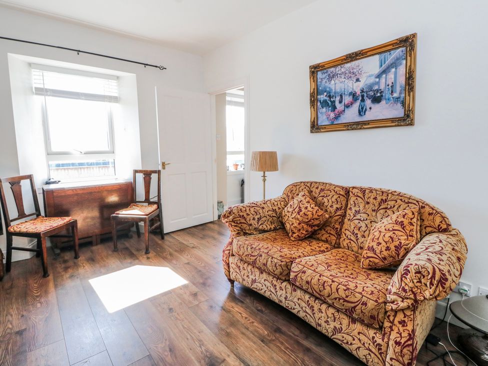 A living room with a sofa and chairs at Schoolhouse in Oban