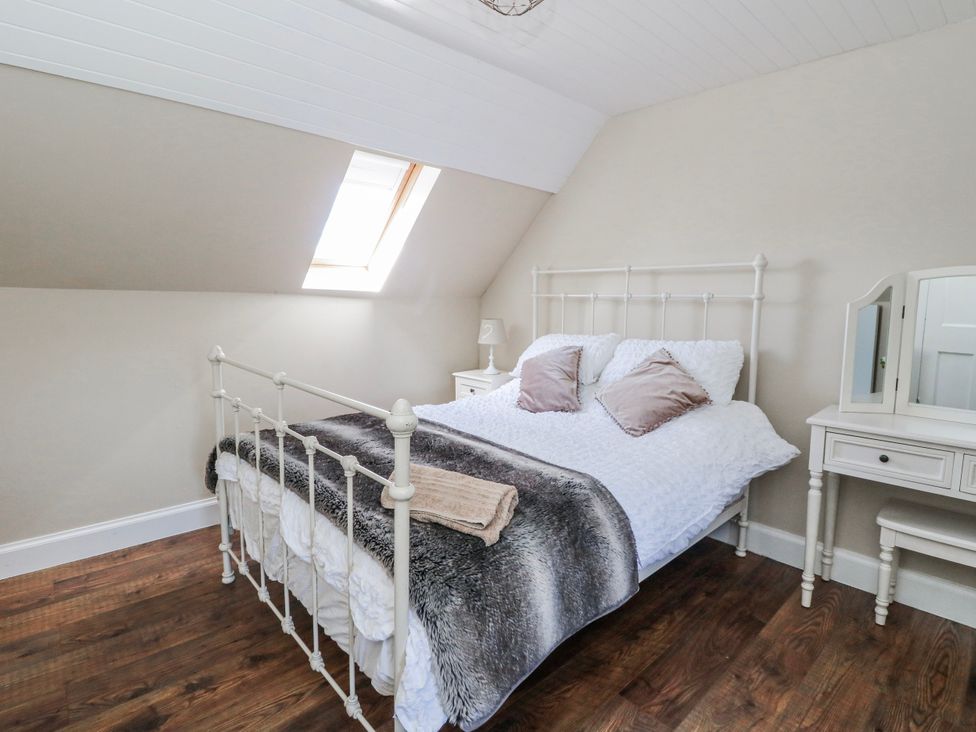 A bedroom with a bed and dressing table at Schoolhouse in Oban