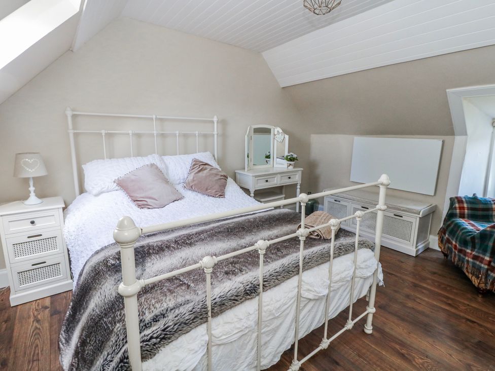 A bedroom with a bed and dressing table at Schoolhouse in Oban