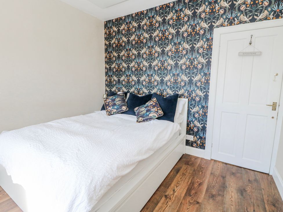 A bedroom with a bed and decorative wall at Schoolhouse in Oban