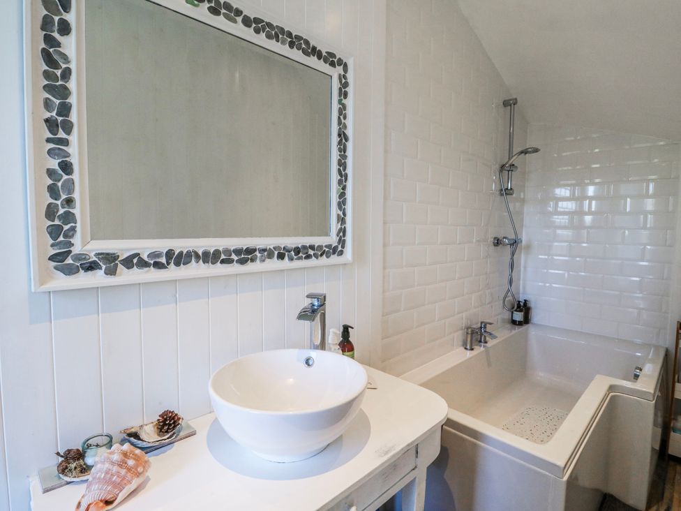 A bathroom with a sink and bathtub at Schoolhouse in Oban
