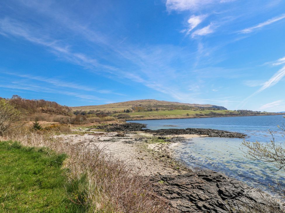 A rocky shore with water and hills at Schoolhouse in Oban