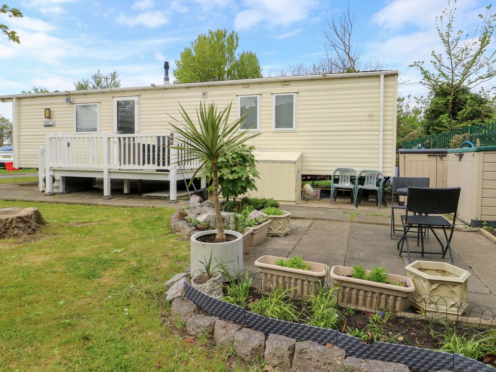 An outdoor area with a mobile home and garden features at W629 in Abergele