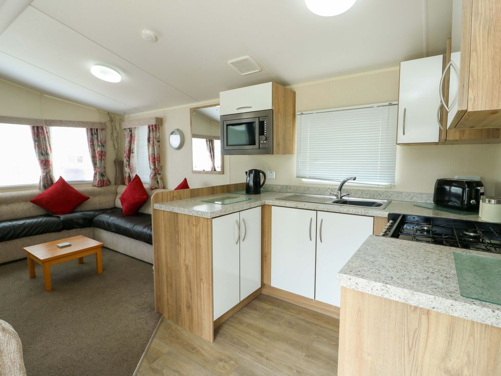 A kitchen and living room area with a sofa and coffee table at W629 Abergele