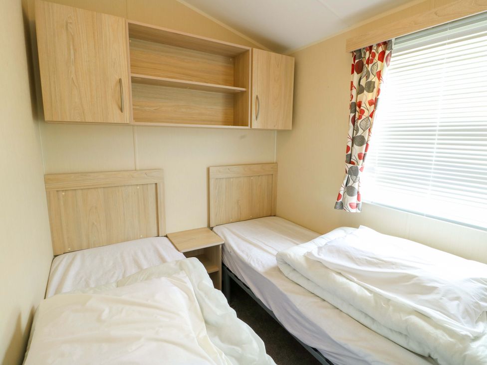 A bedroom with two beds and a shelf at W629 Abergele