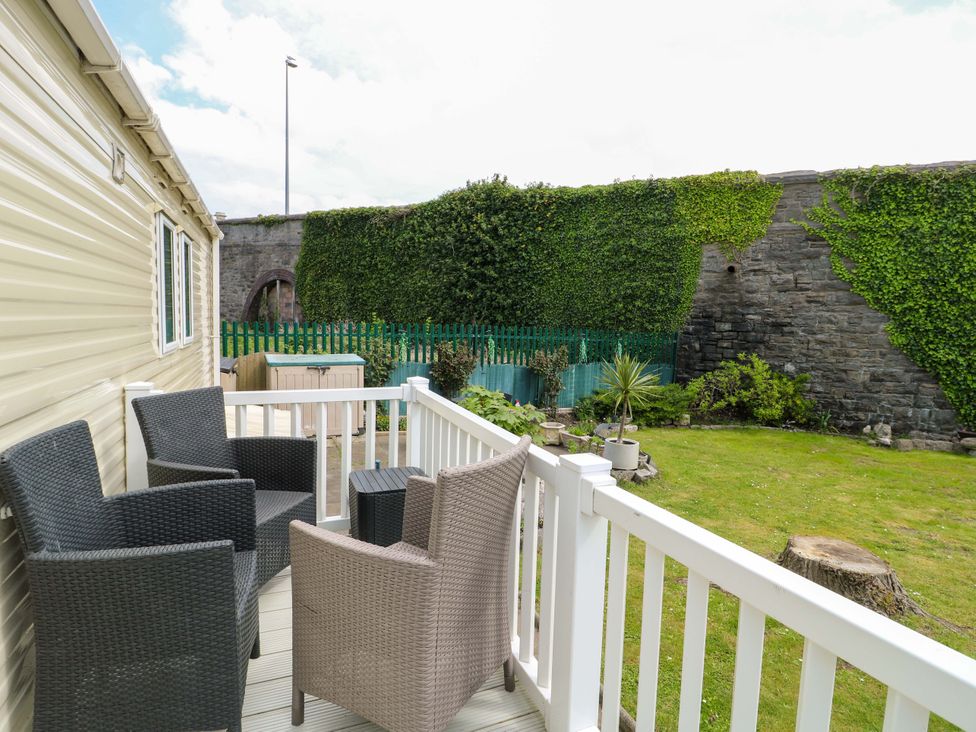 A balcony with chairs and a table overlooking a garden at W629 in Abergele