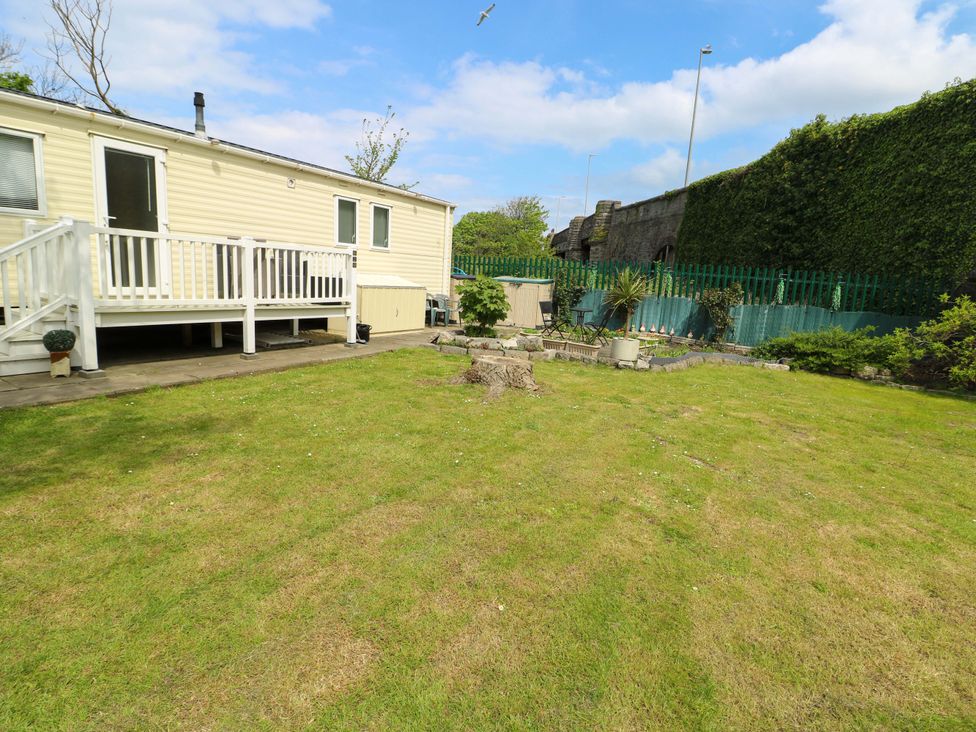 A garden with a caravan and decking at W629 in Abergele