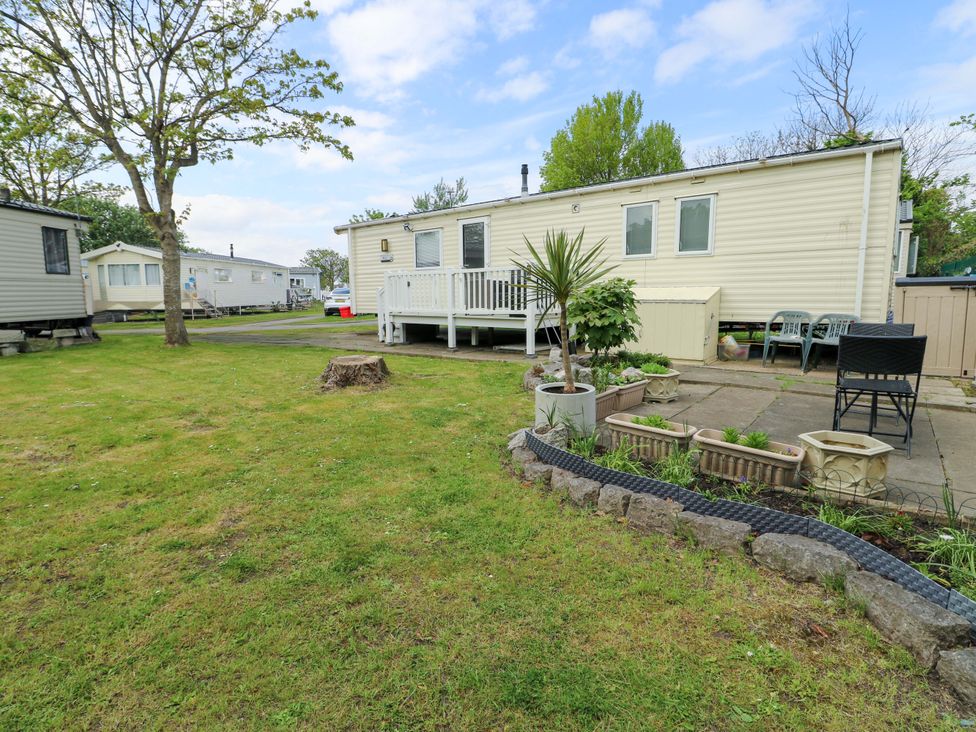 A mobile home with a deck and garden at W629 in Abergele