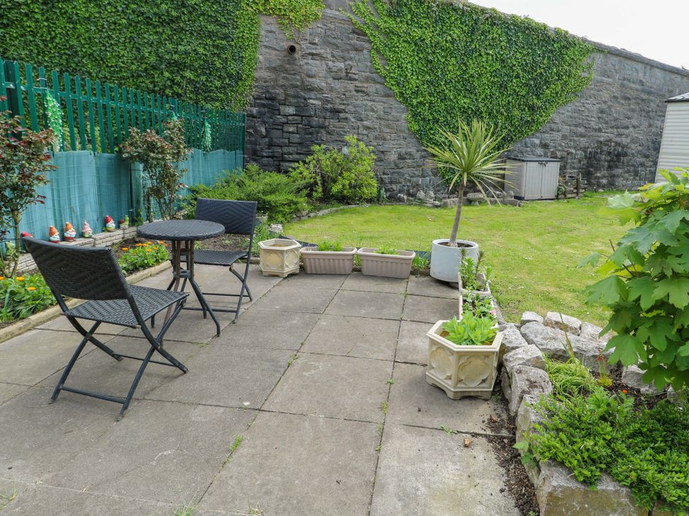 A garden with seating area and planters at W629 in Abergele