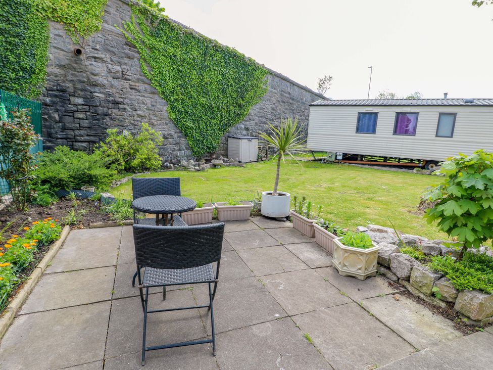 A garden with a patio area and a trailer at W629 Abergele