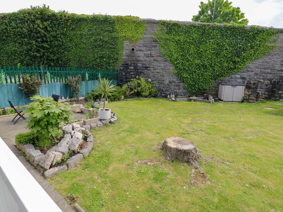A garden with grass and tree stump at W629 in Abergele