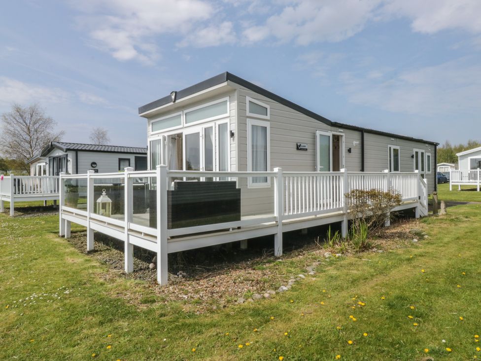 A mobile home with a deck in the outdoor area at Swan Haven in Grange-Over-Sands