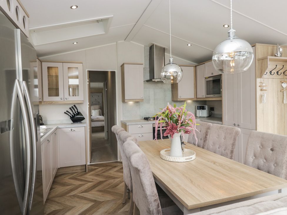 A kitchen with a dining area featuring a table and chairs at Swan Haven in Grange-Over-Sands