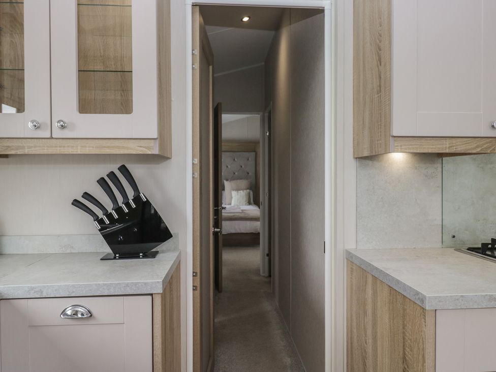 A kitchen with cabinets and a knife block at Swan Haven in Grange-Over-Sands