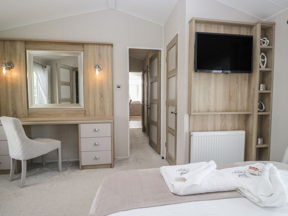 A bedroom with a desk and mirror at Swan Haven in Grange-Over-Sands