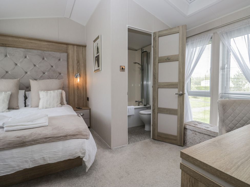 A bedroom with a bed and attached bathroom at Swan Haven in Grange-Over-Sands