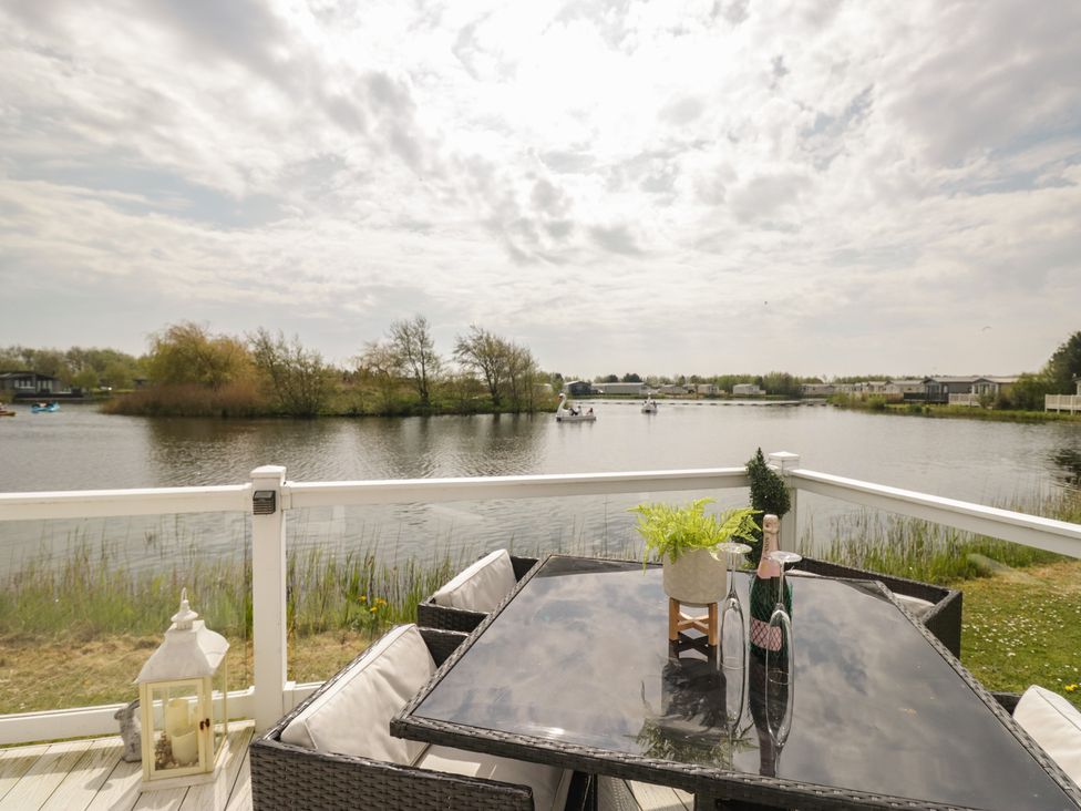 An outdoor dining area with a view of the water at Swan Haven in Grange-Over-Sands