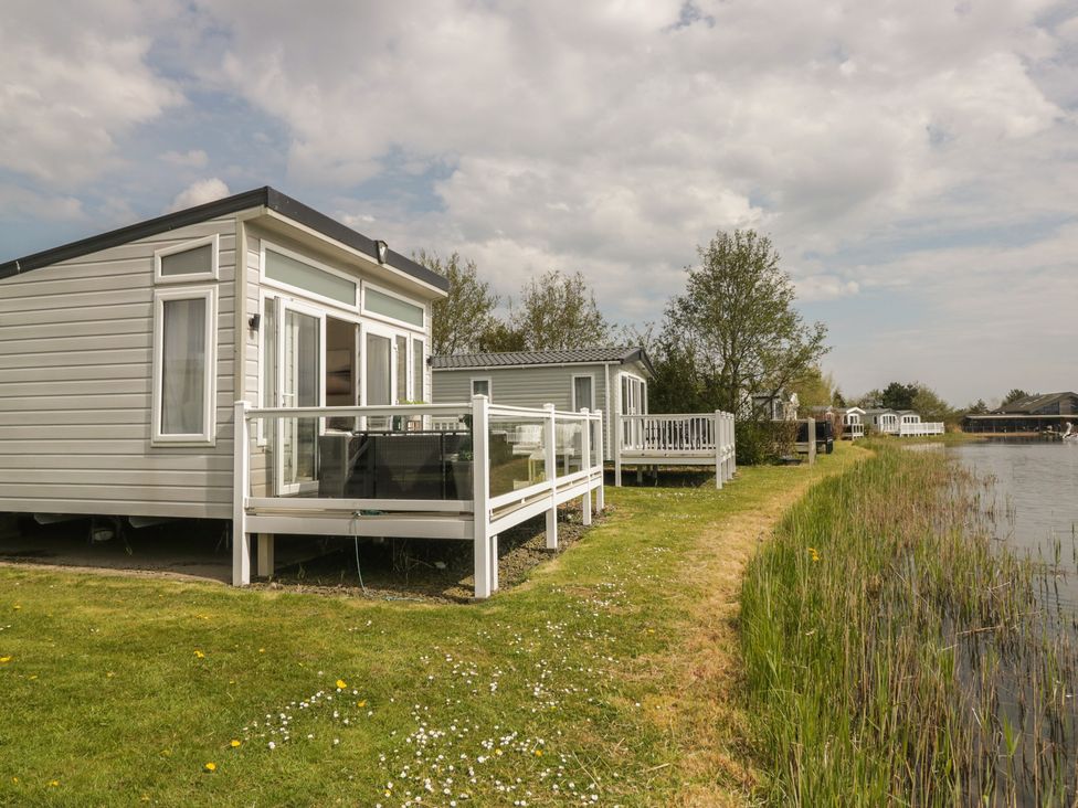 A house with a deck near water at Swan Haven in Grange-Over-Sands