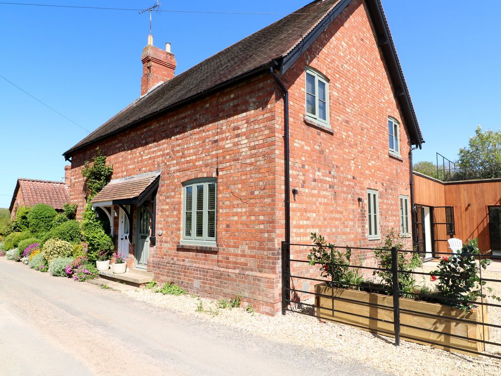 A house with brick exterior and garden at Gardener’s Cottage in Oakham