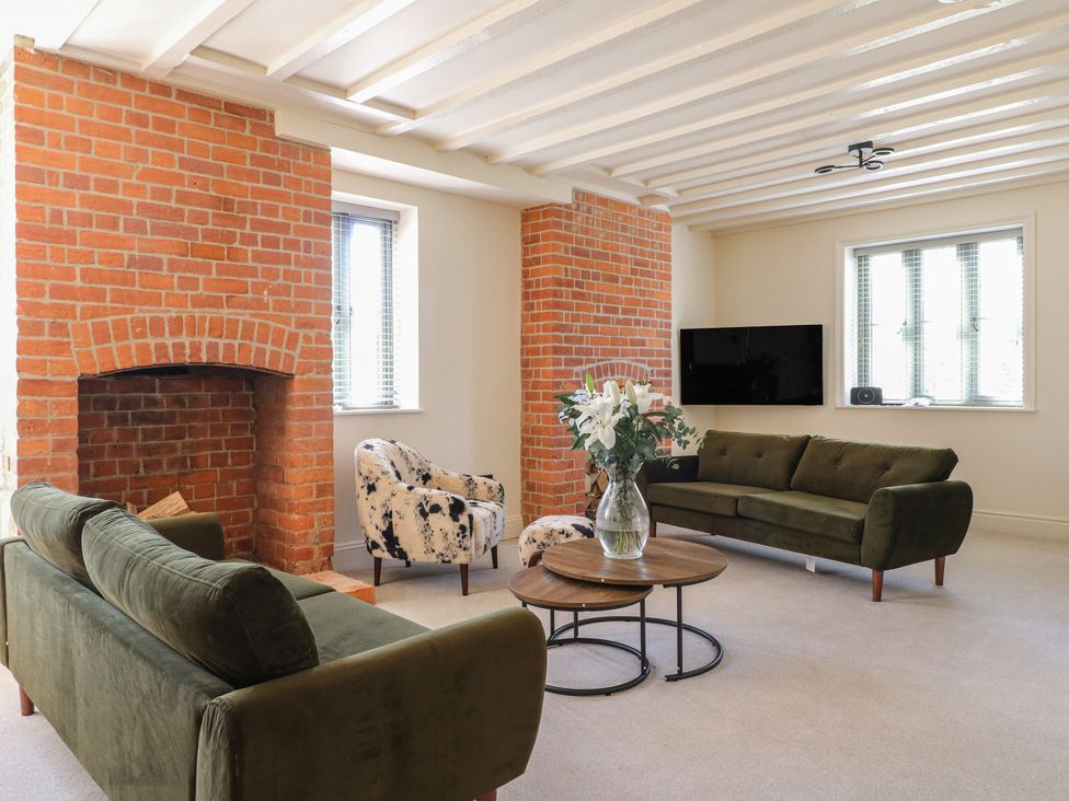 A living room with a sofa and armchair at Gardener’s Cottage in Oakham