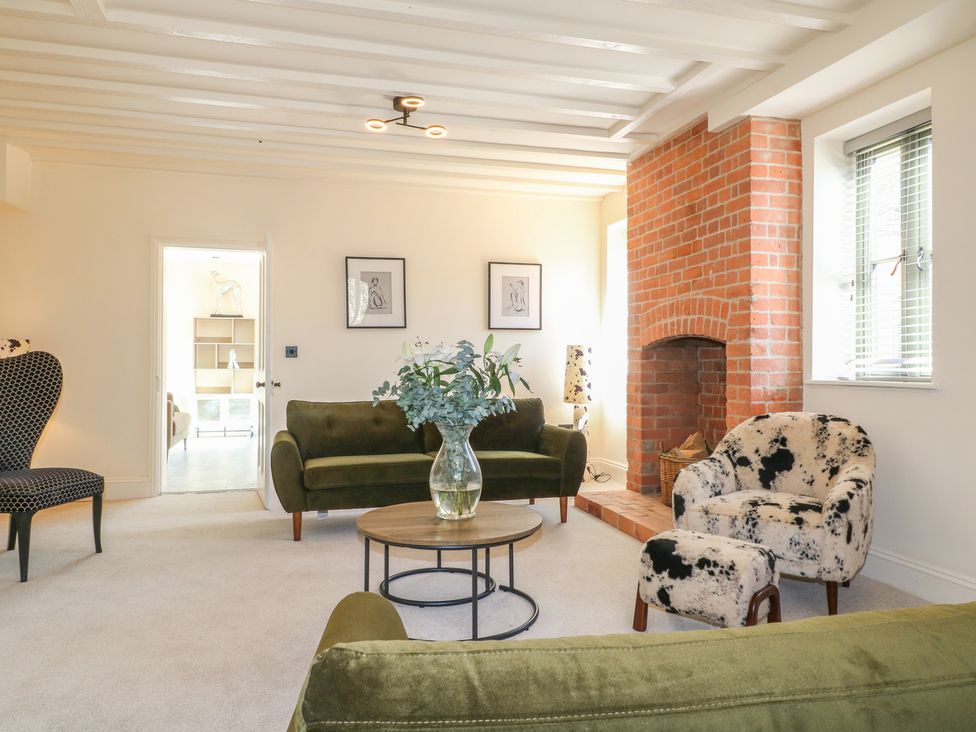 A living room with sofas and a fireplace at Gardener’s Cottage in Oakham