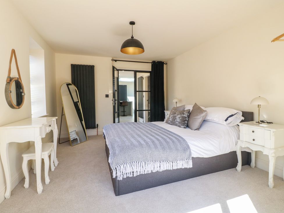 A bedroom with a bed and bedside tables at Gardener’s Cottage in Oakham