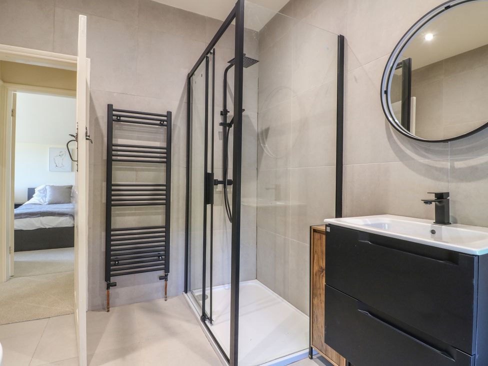 A bathroom with a shower and a vanity unit at Gardener’s Cottage in Oakham