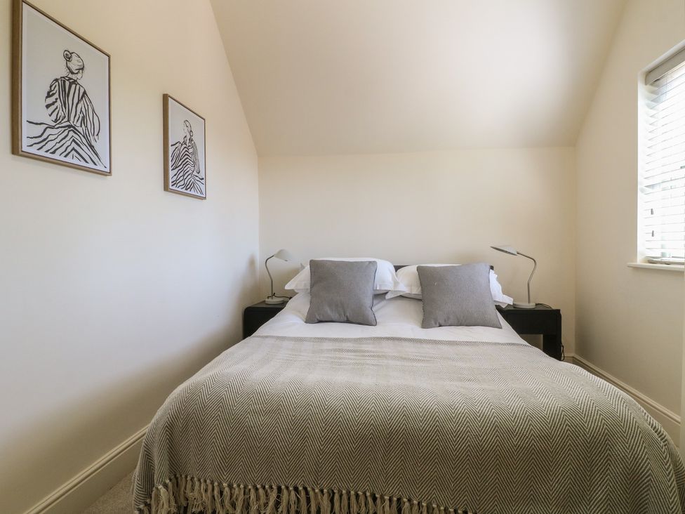 A bedroom with a bed and two artworks at Gardener’s Cottage in Oakham