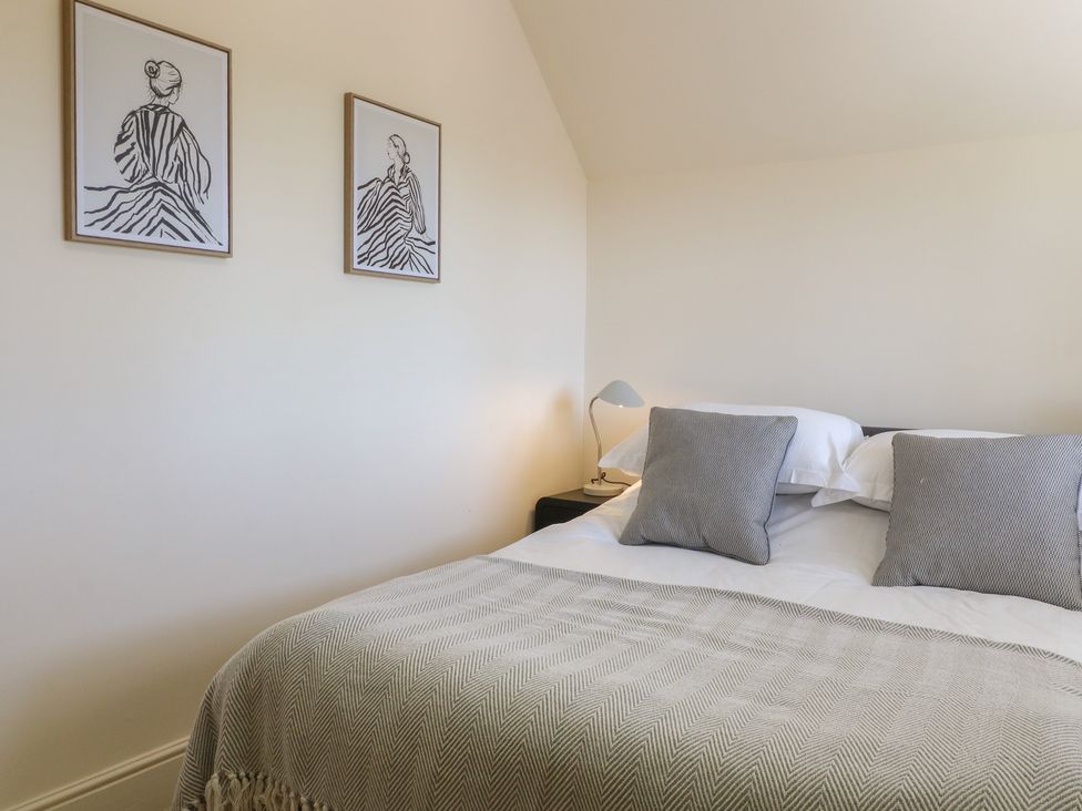 A bedroom with a bed and wall art at Gardener’s Cottage in Oakham
