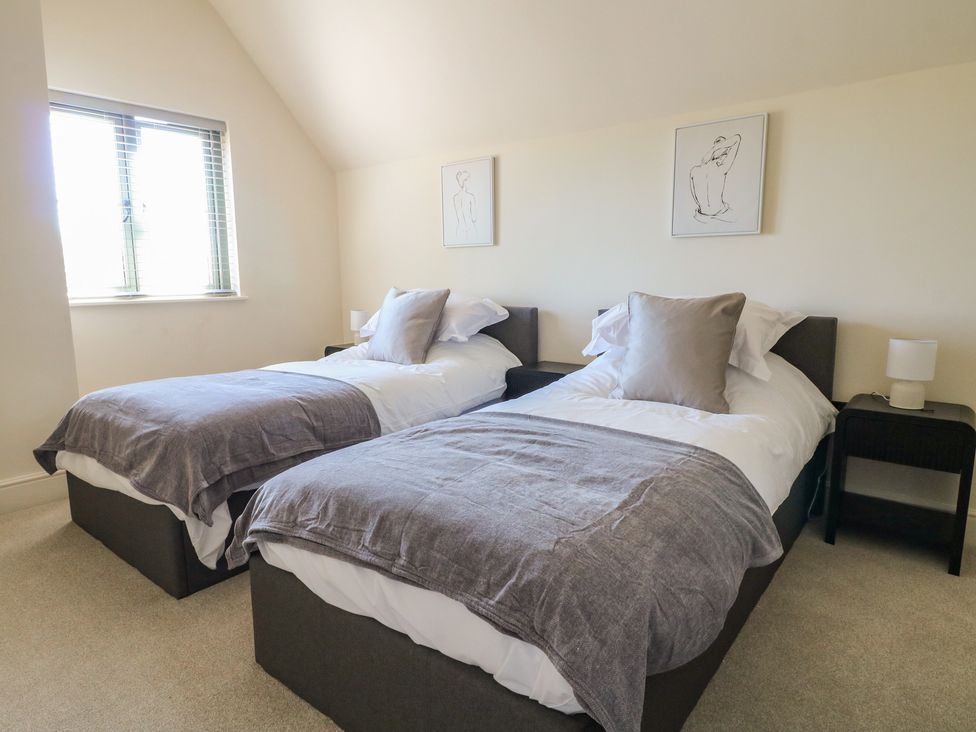 A bedroom with two single beds at Gardener’s Cottage, Oakham