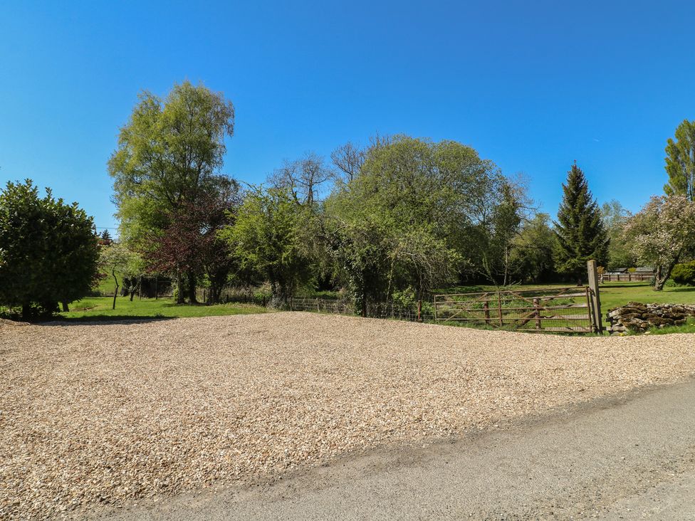 An outdoor area with gravel and trees at Gardener’s Cottage in Oakham
