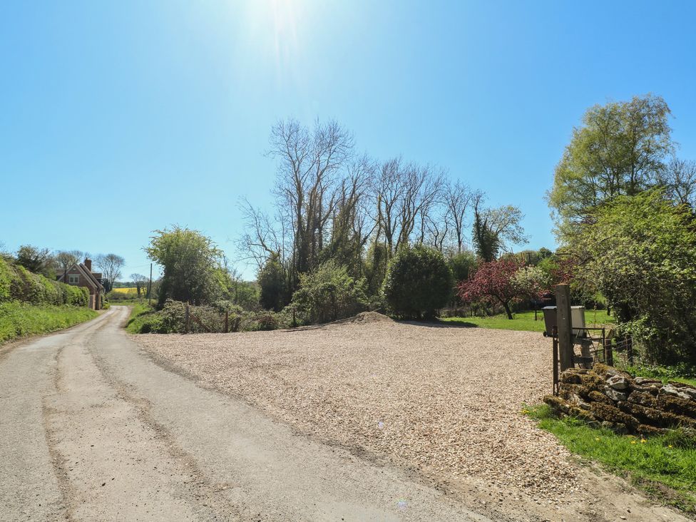 A driveway with gravel and trees at Gardener’s Cottage in Oakham
