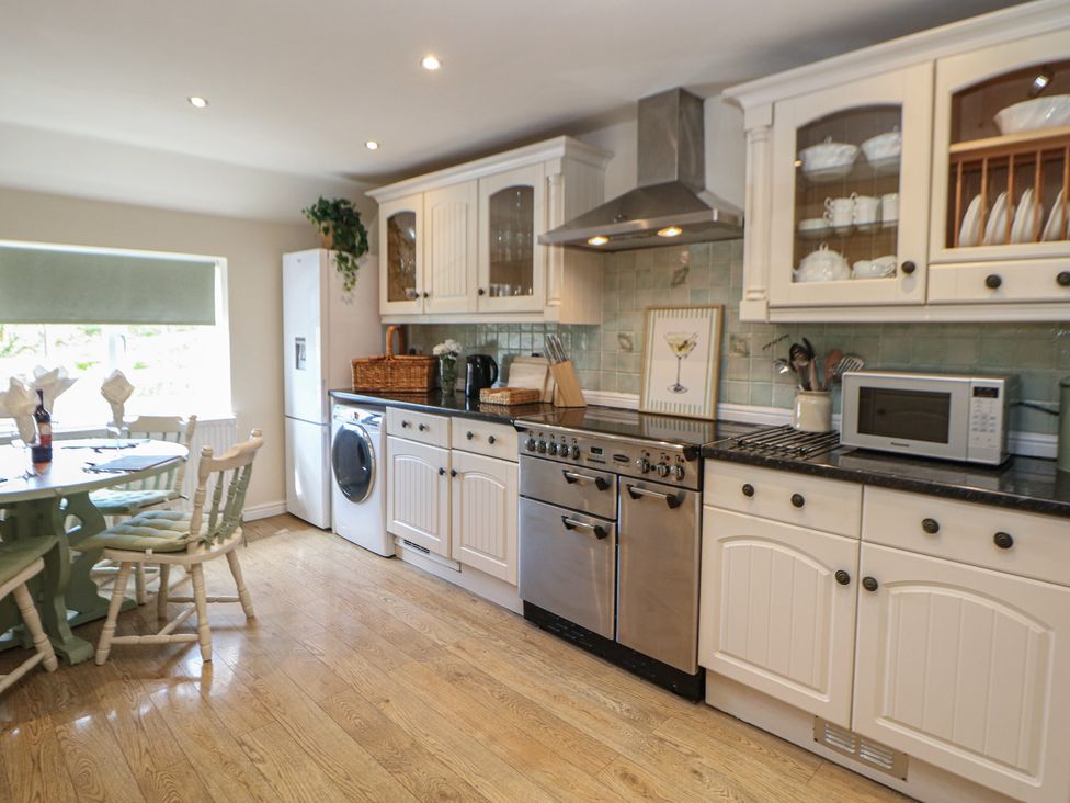 A kitchen with appliances and a dining table at Ivy Cottage in Matlock