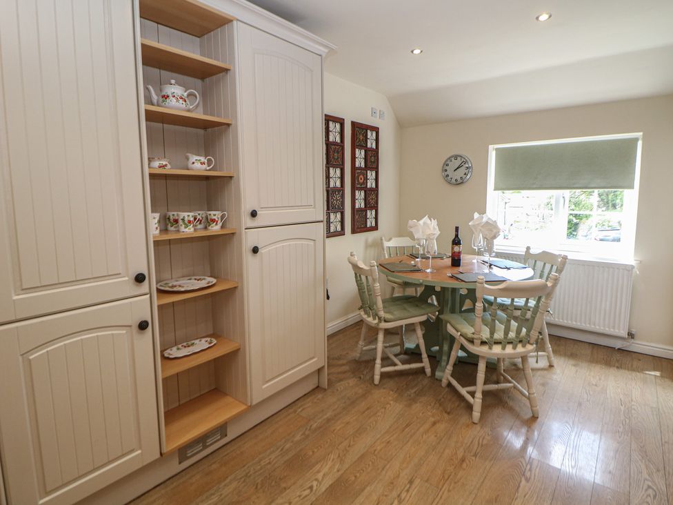 A dining room with a round table and chairs at Ivy Cottage in Matlock