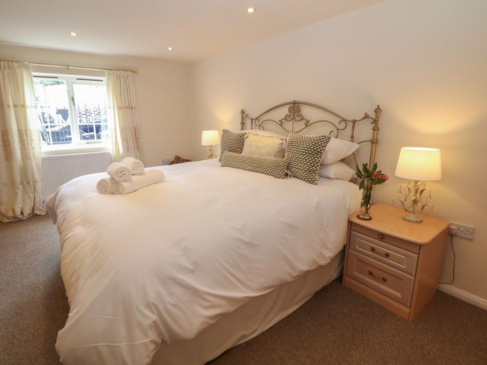 A bedroom with a bed and bedside table at Ivy Cottage in Matlock