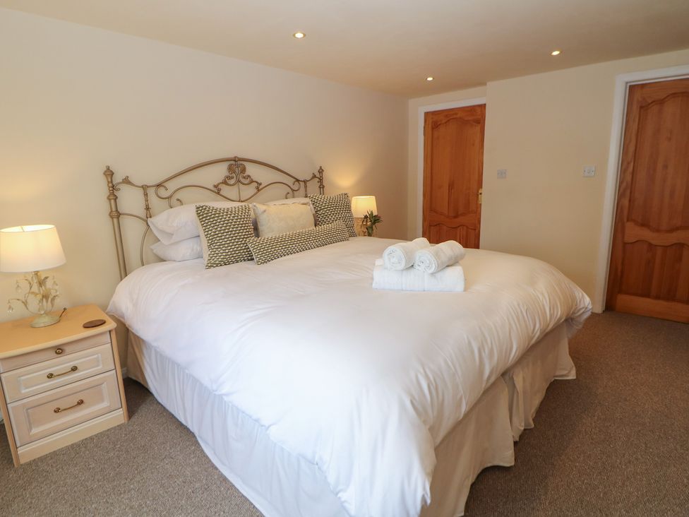 A bedroom with a bed and bedside table at Ivy Cottage in Matlock