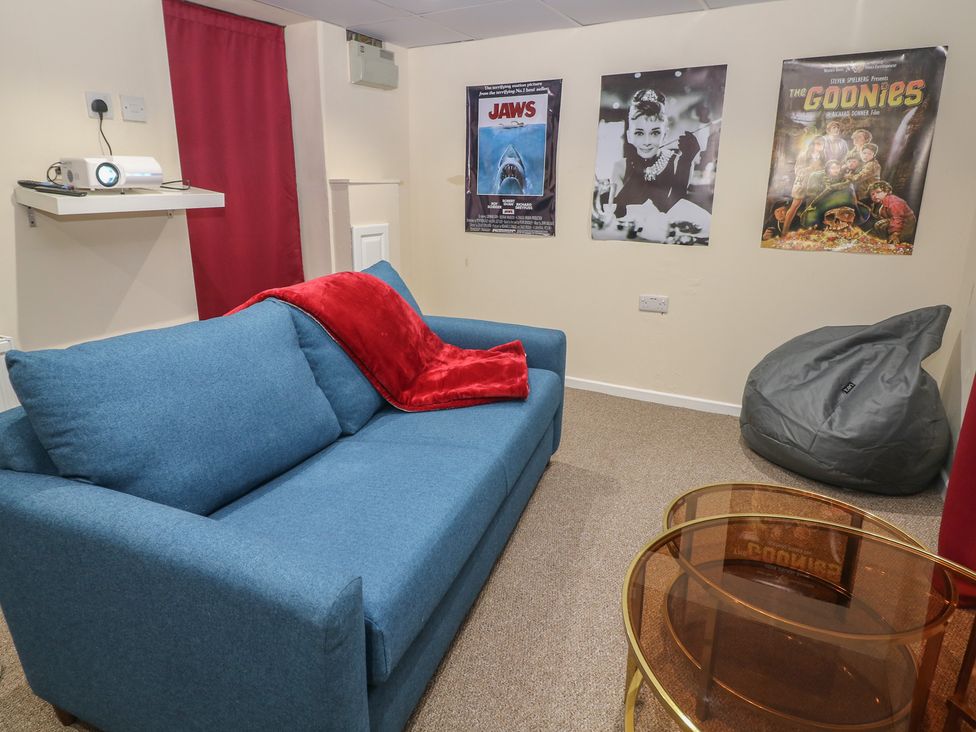 A snug with a blue sofa and movie posters at Ivy Cottage in Matlock