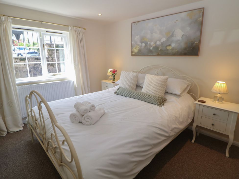 A bedroom with a bed and bedside table at Ivy Cottage Matlock