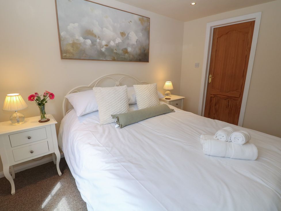 A bedroom with a bed and side tables at Ivy Cottage Matlock