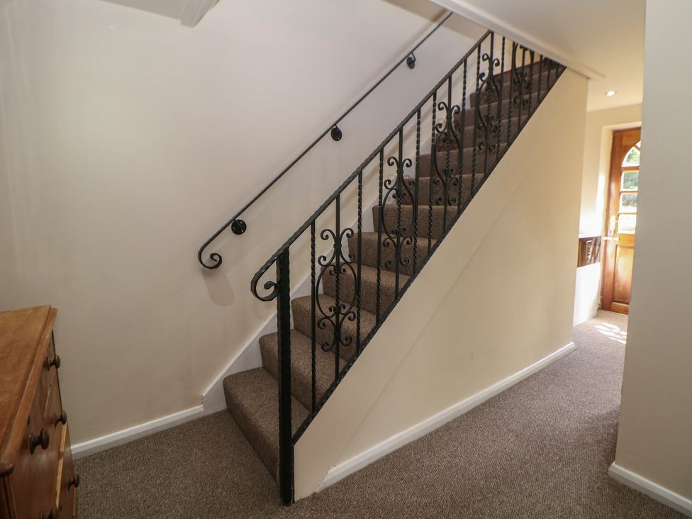 A staircase with a handrail in a hallway at Ivy Cottage Matlock