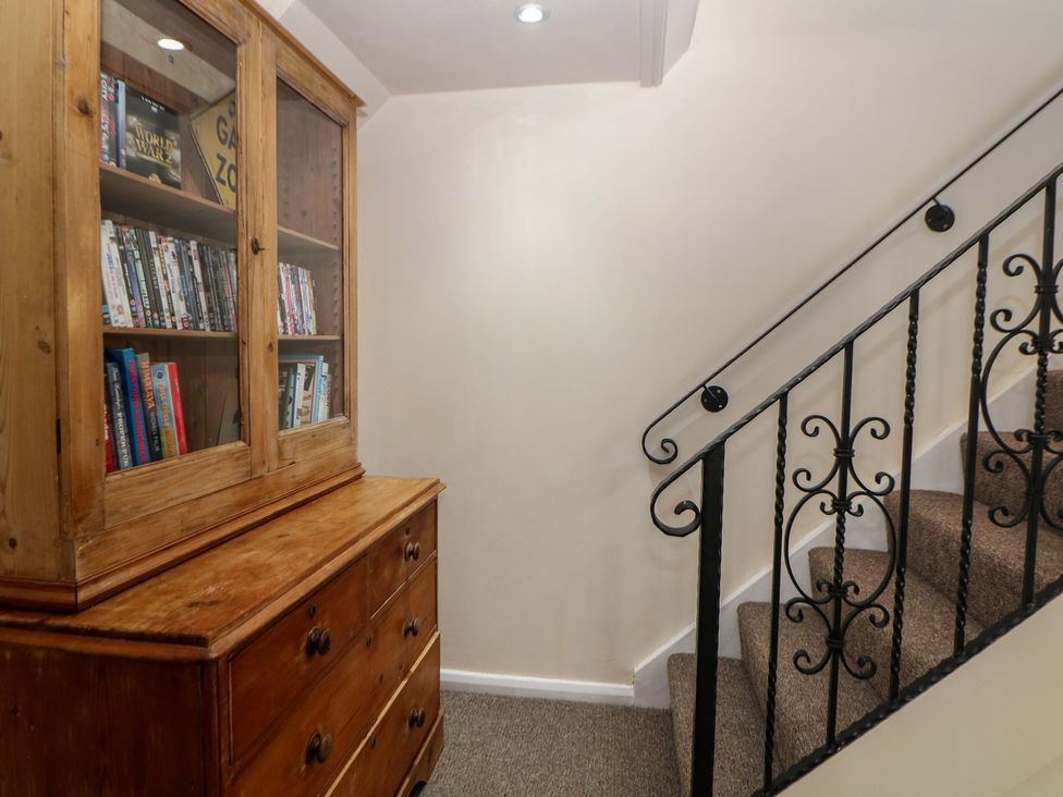 A staircase with a bookshelf and drawers at Ivy Cottage in Matlock