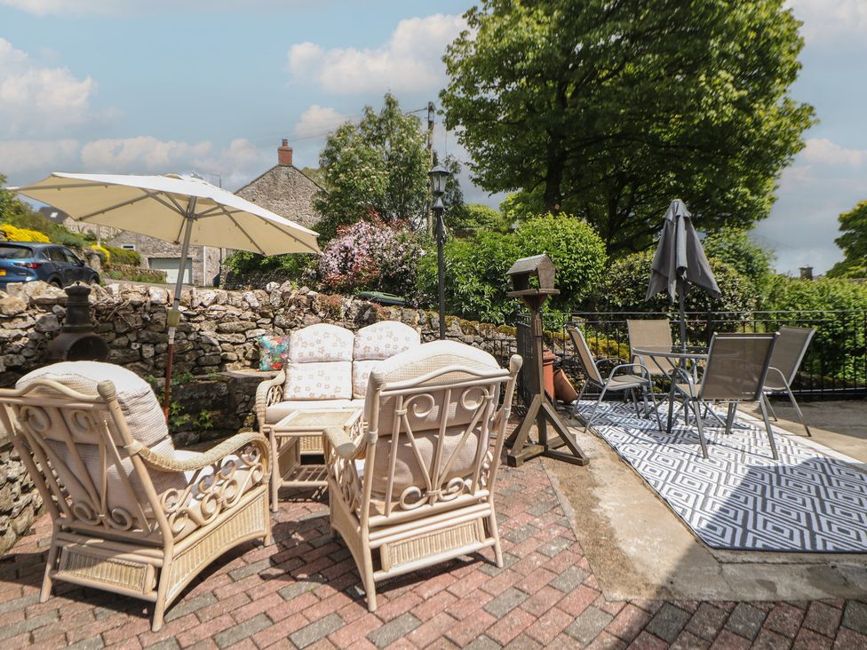 A garden area with seating and an umbrella at Ivy Cottage Matlock