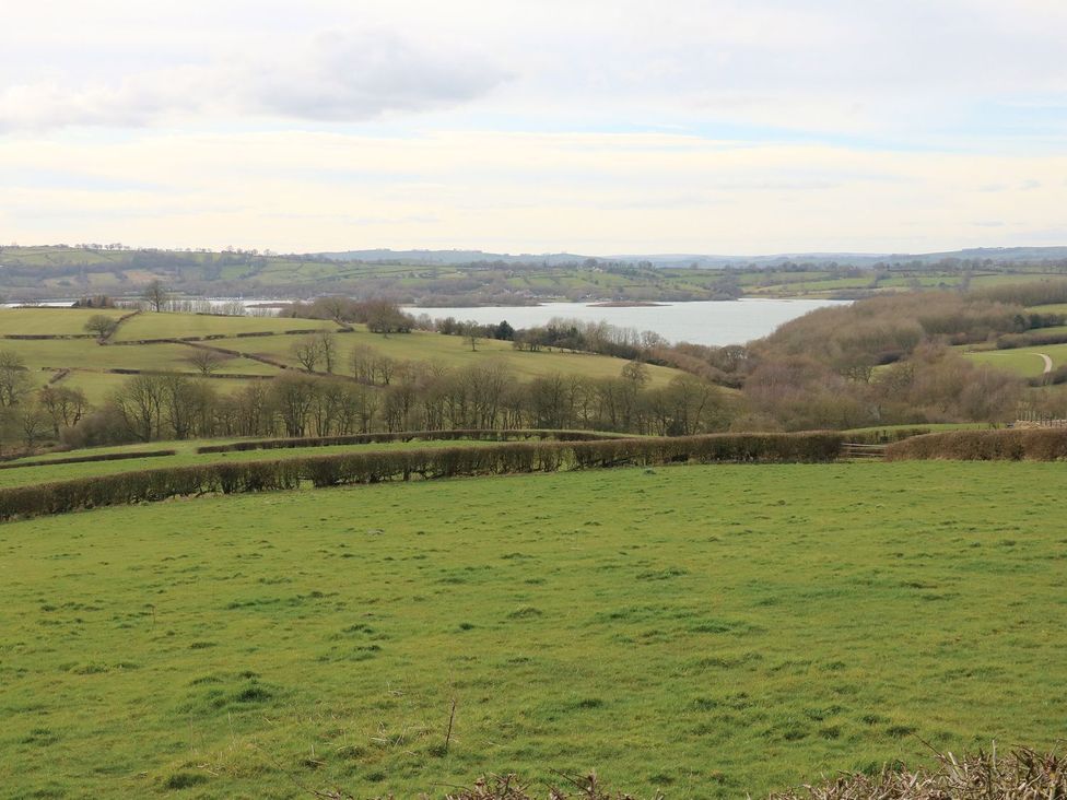 A scenic view of fields and a lake at Ivy Cottage in Matlock