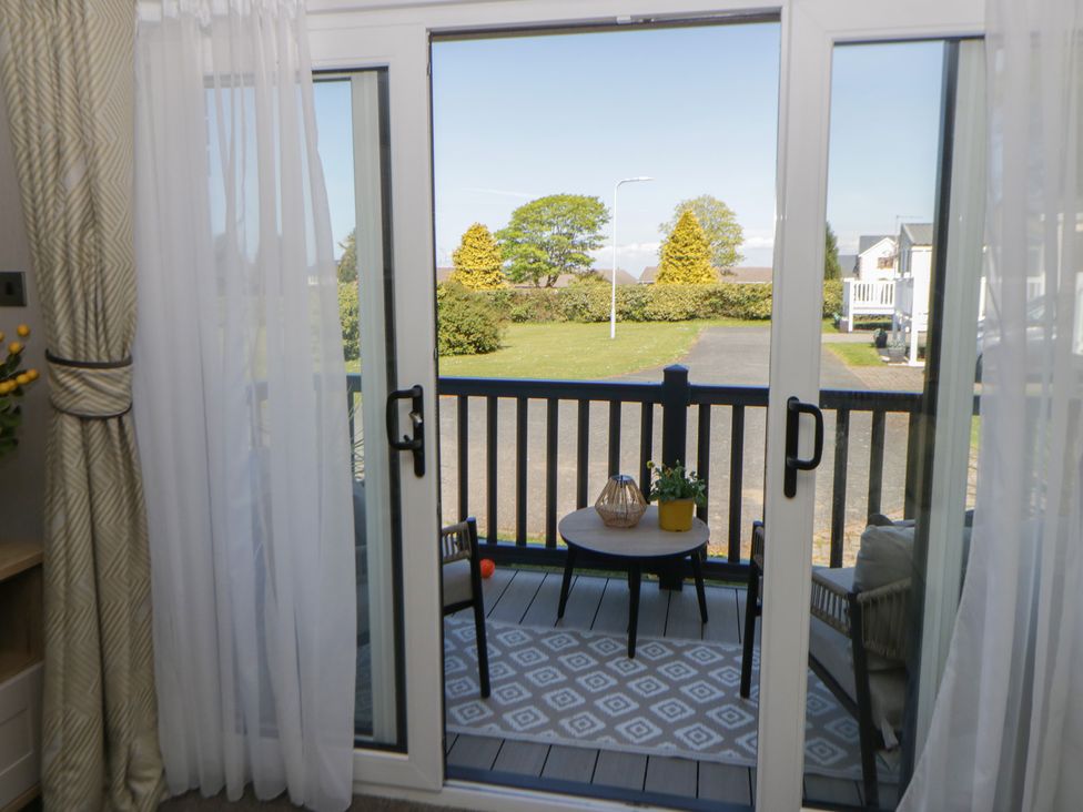 A balcony with a table and chair at Santa Maria in Llandysul